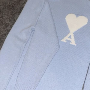 Ljusblå Ami Paris Tröja  - Säljer en ljusblå stickad tröja från Ami Paris storlek M, bra skick använd runt 3-4 gånger. Kom med bud.