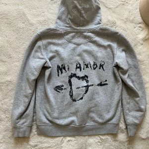Grå Mi Amor hoodie - Grå jättefin Mi Amor hoodie från Mira Paris. Storlek S och eftersom den är unisex så är den något stor i storleken för kvinnor. Knappast andvänd!! Nypris 1100kr❣️