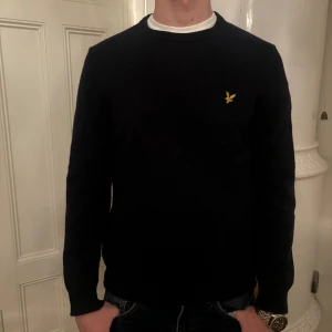 Mörkblå Lyle & scott tröja - Snygg mörkblå tröja i märket Lyle @ scott på bröstet. Tröjan har långa ärmar och en klassisk passform. Perfekt för en stilren look.