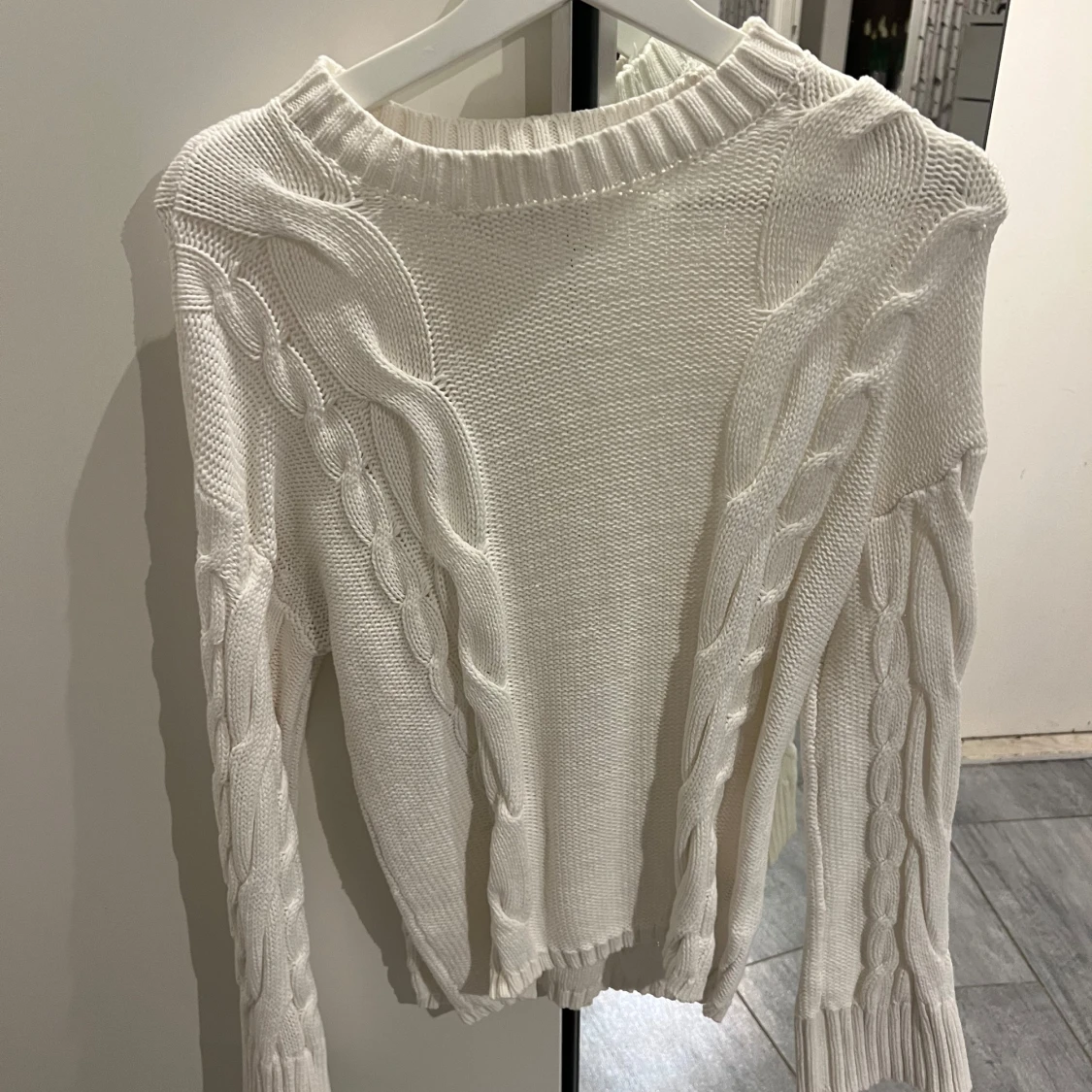 Vit stickad tröja med flätmönster