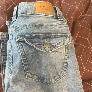 Ljusblå jeans från Perfect Jeans - Snygga ljusblå jeans från Perfect Jeans med klassisk femficksdesign och knappdetalj på bakfickan. Perfekta för en avslappnad stil. Nypris 499kr pris går att diskutera 