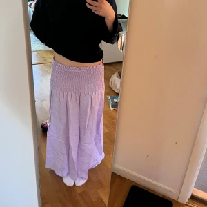 Ljuslila långkjol från Kappahl - Säljer en helt oanvänd ljuslila långkjol från Kappahl. Plagget kan användas både som en kjol men oxå som en kortare klänning. Som kjol når den precis ner till golvet på mig, (jag är 162cm lång). Den är lite skrynklig men går jättebra att strykas bara!