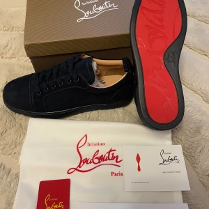 Mörkblåa sneakers från Christian Louboutin - Säljer ett par mörkblåa sneakers från Christian Louboutin med klassisk röd sula. Skorna är i superbra skick ☺️dessutom skickas de direkt 