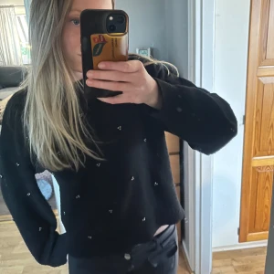 Svart stickad tröja med pärldetaljer - Säljer en svart stickad tröja med små pärldetaljer utspridda över hela tröjan. Tröjan har rund halsringning och långa ärmar. Den är lite nopprig. Perfekt för dig som vill ha en enkel men ändå unik look. Jag har köpt den på hm💗💗