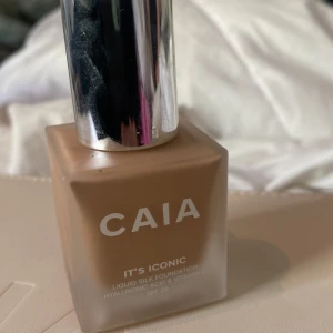 CAIA It's Iconic Liquid Silk Foundation 3N - Flytande foundation från CAIA i nyansen 3N. Kommer i en lyxig, silvrig förpackning. Innehåller hyaluronsyra och vitamin C för extra vårdande effekt. Ger en naturlig finish och passar normal hudton.