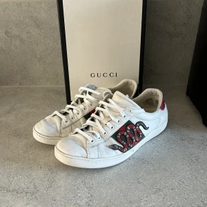 Gucci Ace sneakers - Gucci Ace sneakers i vitt skinn med ikonisk röd och svart orm brodyr på sidan. Sick7/10 pga bild nr3 allt OG medföljs. Hör av er vid minsta frågan. //dexter