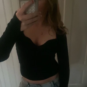 Svart ribbad långärmad topp - Säljer min jättefina svarta ribbade långärmad topp med v-ringning. Jag köpte den för ca 2 år sedan från H&M och använt den några få gånger, men den är i ett väldigt fint skick! Varför jag säljer den är för att jag inte har någon användning av den!🥰