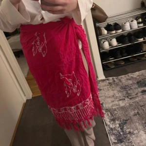 Rosa sarong  - Köpt utomlands. Mycket bra skick! Kan användas på många olika sätt. Fin att ha med bikini  Längd : ca 153x105 cm
