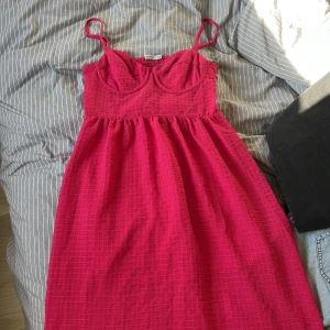 Rosa sommarklänning med smala axelband - Säljer en rosa klänning med smala axelband och markerad byst. Lätt att stylea! Ny lite för liten i bysten för mig, skulle säga att den passar en S/M/L så länge man har lite mindre överkropp! Se sista bilderna för referens :) 
