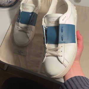Valentino sneakers med blå detalj - Säljer dessa tvär fetta Valentino open skorna 😻|| Skorna är i en ljusare nyans av Marina blå och är därför perfekta till sommaren|| skorna är i 8/10 skick o ett snöre ( skriv efter bild !!!)är lite skadat men någon sömn vid toe boxen har släppt se på bild 3 || pris ej hugget i sten💸💸