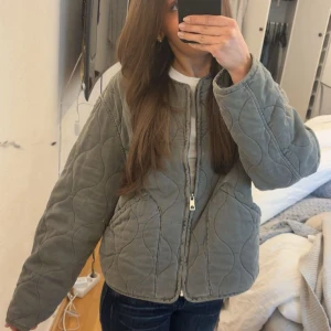 Quiltad jacka från Zara - Superfin mörkgrå quiltad jacka från ZARA! Helt ny och oanvänd men har tagit bort lappen! Storlek 12-13 år (156)💕 Helt slutsåld på hemsidan, nypris: 499kr! 