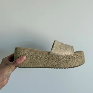 Beige platåsandal med flätad sula - Snygga beige sandaler med bred rem och hög platåsula. Perfekta för sommaren🌸💞 Öppen tå och enkel slip-in modell.  Köpta på en marknad i Marbella 