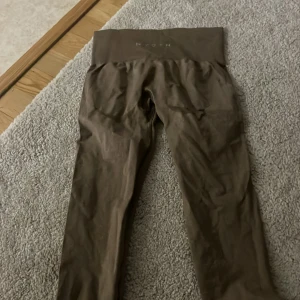 Bruna seamless tights från NVGTN - Säljer ett par bruna seamless tights från NVGTN med hög midja. Perfekta för träning eller chill, med stretchigt material som sitter skönt på kroppen. 
