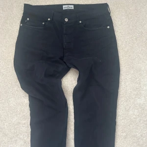 Mörkblå byxor från Stone Island - Säljer ett par mörkblå byxor från Stone Island med klassisk femficksdesign och ikonisk logotyp på bakfickan. Byxorna har normal passform och stängs med knapp och dragkedja. Perfekta för dig som gillar stilrena och exklusiva plagg.