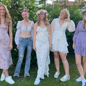 Vit långklänning med blommigt mönster och volang - Säljer en romantisk vit långklänning med blommigt mönster och volangdetaljer. Klänningen har smala axelband och omlottkänsla framtill. Perfekt för sommarens alla tillfällen och midsommarfirande.