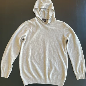 Beige hoodie från Oscar Jacobson - Säljer en stilren beige hoodie Storlek:S från Oscar Jacobson i mjukt material. Perfekt för en avslappnad och snygg look, perfekt till sommaren . Använd varsamt och fåtal gånger, inga defekter eller fläckar. 