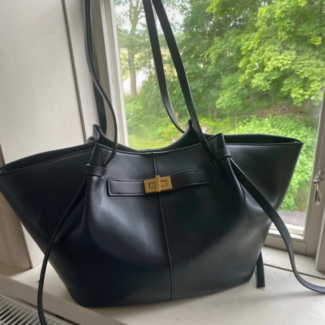 Svart axelväska i skinn med gulddetalj