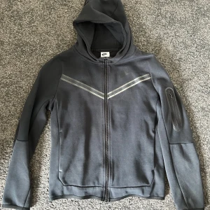 Nike tech hoodie  - Säljer en svart Nike Tech Fleece hoodie. Snygg, stilren och sjukt bekväm – passar både till vardags och när du vill se lite extra vass ut.
