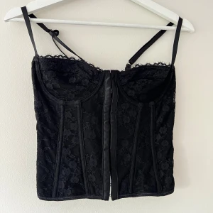 Svart korsett  - Säljer denna svarta korsetten med fina detaljer 💋 man knäpper den fram och sen har den snörning i ryggen! Passar storlek xs/s 