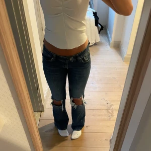 Lågmidjade Jens - Lågmidjade jeans med hål i knänen. Använt 2 gånger! Storlek: 34