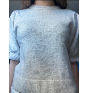 Ljus stickad tröja från Gina Tricot - Super söt beige stickad kortärmad tröja från Gina Tricot med puffiga armar. Nypris 200kr. Har bara används 2 gånger så jättebra skick! Storlek 158-164 men är ganska kort. Säljer för att den inte kommer till användning.💕