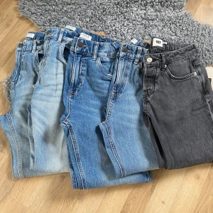 5-pack jeans i olika blå och svart - Säljer fem par jeans i olika tvättar från Lindex och 157. Färgerna är ljusblå, mellanblå och svart. Klassisk femficksmodell med raka ben och normal passform. Perfekta för dig som gillar enkel och tidlös stil. Materialet är slitstark denim i bomull. Alla dem är storlek 170. Sammanlagt kan du få dem för 350, men du kan köpa ett par för 90.