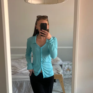 Blå ribbad skjorta från Bik Bok - Säljer min helt oanvända fina blåa långärmad skjorta från Bik Bok i ribbad, lätt transparent material. 