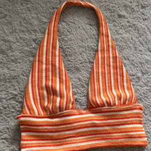 Randig halterneck topp från H&M - Säljer en snygg randig halterneck topp från H&M i orange och vitt. 