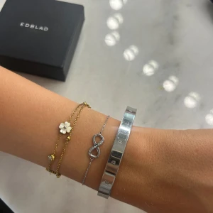 Silverarmband med evighetssymbol Edblad - Stilrent silverfärgat armband från Edblad med en tunn kedja och en glittrig evighetssymbol dekorerad med små stenar. Levereras i original ask. I nyskick!