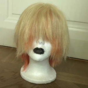 Tsukasa tenma peruk - Kort peruk med rak frisyr och lugg. Håret är blont med persikofärgade toppar som ger en cool ombre-effekt. Perfekt för cosplay, maskerad eller när du vill byta stil snabbt. Syntetmaterial som är lätt att styla och bära. Köpt för ett tag sen på Amazon. Peruken är av hög kvalitet och är tänkt till karaktären Tsukasa Tenma från pjsk.