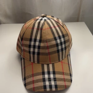 Burberry Keps- Helt Ny! - Säljer en stilren och helt ny Burberry keps, aldrig använd. Klassisk design med det välkända Burberry-mönstret – perfekt för dig som gillar exklusiva accessoarer med attityd.  🎁 Fick den nyligen i present men den passade inte min stil, så nu får någon annan chansen istället. 💸 Säljes för 500 kr, vilket är ett riktigt kap. 📍 Finns i Västerås– kan mötas upp eller skickas mot frakt. 🧢 Justerbar passform – passar både dam och herr. Skicka ett meddelande om du vill slå till-först till kvarn gäller!