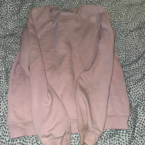 Ljusrosa sweatshirt från 157, XS - Enkel och snygg ljusrosa sweatshirt från 157 i storlek XS. Tröjan har rund halsringning, långa ärmar och ribbade muddar vid ärmslut och nederkant. Perfekt för en chill och avslappnad stil.