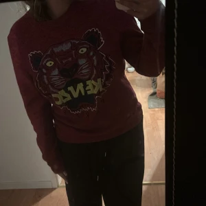 Röd Kenzo sweatshirt med tigertryck - Säljer denna vinröda/lila kenzo sweatshirten, den är jättebekväm och är väldigt snygg, den är i perfekt skick och har inga tecken på användning. Säljer den då den inte har kommit till användning och har aldrig använt den💞