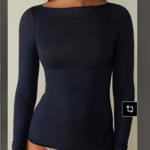 Populär intimissimi tröja - Säljer en mörkblå, tight och långärmad topp med rundad halsringning. Toppen är enkel och stilren, perfekt att matcha med jeans eller kjol. Tillverkad i mjuk bomull som sitter skönt mot kroppen. Töjan är något uttöjt men krymper lite i tvätten. Köpt för 550kr, priset kan diskuteras 