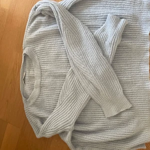 Ljusblå stickad tröja från Chiquelle - Supermysig ljusblå stickad tröja från Chiquelle med rund halsringning och ribbade muddar. Tröjan har en loose fit och är perfekt för lager-på-lager. Passar dig som gillar en enkel men stilren look.