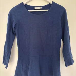 Blå långärmad topp från Boomerang - Superskön blå långärmad topp från Boomerang i modellen Luna. Tillverkad i mjuk bomull med rund halsringning och lätt utställd nederdel. Perfekt för dig som gillar enkel och stilren design med en chill vibe.