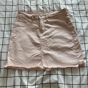 Ljusrosa jeanskjol från JDY Denim - Superfin ljusrosa jeanskjol från JDY Denim med rå kant nertill och klassiska fickor både fram och bak. Kjolen är kort och har en snygg, enkel design som passar perfekt till en avslappnad look.