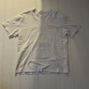 Vit t-shirt från Polar Skate Co. - Säljer en vit t-shirt från Polar Skate Co. med liten logga på bröstet och stor grafisk illustration på ryggen. Klassisk passform och rund halsringning. Perfekt för dig som gillar streetwear och skate. Vill även tillägga att den är baggy!