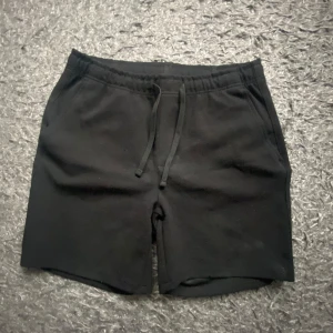 Svarta shorts från Zara med snörning - Svarta shorts från Zara med elastisk midja och snörning framtill. Klassisk rak passform med fickor på sidorna och två bakfickor. Perfekta för sommaren. Använda 1-2 gånger, säljs pga för små.
