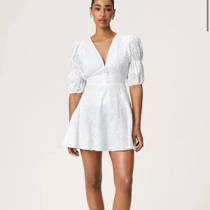 Adooreklänning Siciliy  - Supersöt vit klänning från Adoore med v-ringning, puffärmar och knappar framtill. Superfint skick!! Säljer då ha köpte en annan storlek🫶 