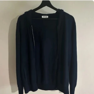 Mörkblå hoodie med dragkedja från Soft Goat - Mörkblå hoodie från Soft Goat med dragkedja framtill och huva. Tröjan är enkel och stilren, perfekt för en avslappnad look. Tillverkad i kashmir. Skick: 9/10. Skickar gärna fler bilder med mått eller liknande privat. Tveka inte på att höra av dig vid eventuella funderingar. 