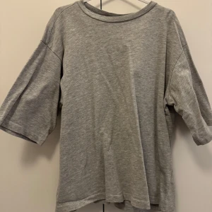 Grå t-shirt med vida ärmar från 157 - Säljer en enkel och stilren grå t-shirt från 157 med vida trekvartsärmar. Tröjan är i lite hårdare material och har en avslappnad passform. Perfekt till vardags och lätt att matcha med olika outfits. Går ner i pris vid snabb affär!💕