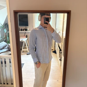 Ljusblå linneskjorta från H&M - Säljer en ljusblå skjorta i linne från rimey. Skjortan har klassisk krage, långa ärmar och knäppning framtill med vita knappar. Perfekt för en stilren och avslappnad look. Nypris runt 1200kr. Skjortan är i väldigt bra skick 9,5/10 endast använd nån gång. Passar S men också M om du gillar att den sitter lite tajtare. Skriv för frågor eller annat!