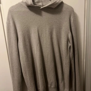 Grå hoodie från Oscar Jacobson - Säljer en stilren och bekväm beige stickad hoodie från Oscar Jacobson. Perfekt för både vardag och avslappnade tillfällen. Tillverkad i Italien med högkvalitativt material som känns mjukt mot huden. Passar perfekt till höst och vinter. 🧥sitter väldigt smått i strl så rekommenderas för nån som bär m vanligtvis den är använd under 5 gånger och nypris ligger på 1600kr jag begär enbart 450kr