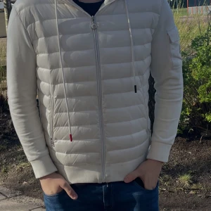 Vit pufferjacka med huva från Moncler - Tja säljer nu min Moncler cardigan. Den är är lite smutsig men det finns fortfarande  liv i jackan. Osäker på äktehets skriv om fler bilder. Har inget pris så kom me bud. Alla bud är välkomna.