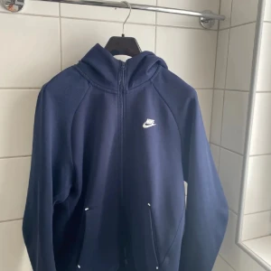 Nike Tech Fleece  - Tja, säljer min marinblåa Nike tech fleece. Modellen på tröjan säljs inte och är väldigt svår att få tag på, tröjan är 10/10 skick. Inga defekter eller så, om du är intresserad eller har frågor så är det bara att höra av sig 🤝