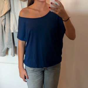 Mörkblå offshoulder topp - Mörkblå topp med offshoulder. T-shirten har lös passform. Står storlek XL men passar mycket bra på mig som använder XS/S