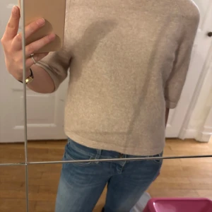 Beige stickad tröja från & Other Stories - Säljer en beige stickad tröja från & Other Stories Stockholm Atelier. Tröjan har rund halsringning och halvlånga ärmar. Perfekt för lager-på-lager och enkel att matcha med jeans eller kjol.