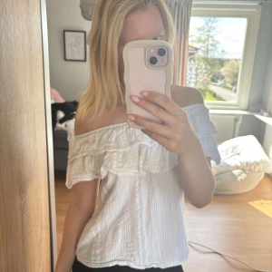 Vit offshoulder blus med volang - Säljer en söt vit offshoulder blus med volangdetalj upptill. Toppen har en luftig och lätt struktur, perfekt för varmare dagar. 💓
