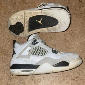 Vita och svarta Air Jordan sneakers - Säljer ett par klassiska Air Jordan sneakers i vitt och svart med grå detaljer. Skorna har snörning, meshpaneler på sidorna och den ikoniska Jumpman-loggan på tungan och sulan. Perfekta för dig som gillar streetwear och sportig stil. Lite smutsiga men jag rengör dom innan de skickas, använt få tals gången